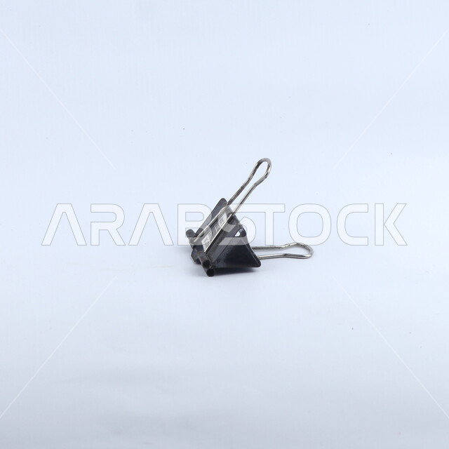 ملقط أوراق أسود اللون, قرطاسيه, أدوات مكتبيه, خلفيه بيضاء