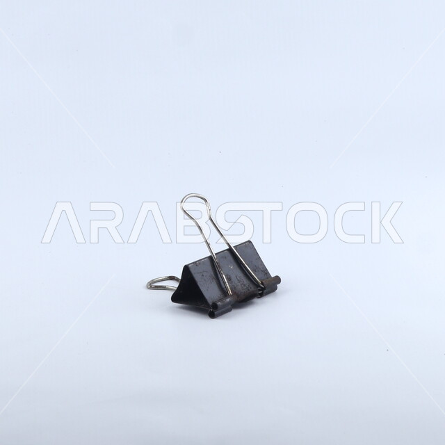 ملقط أوراق أسود اللون, قرطاسيه, أدوات مكتبيه, خلفيه بيضاء