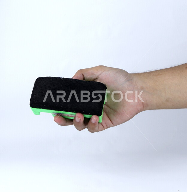 صوره مقربه ليد تمسك بمساحة السبوره البيضاء, مساحة اسفنجيه لمسح اقلام السبوره, قرطاسيه, أدوات مدرسيه, خلفيه بيضاء