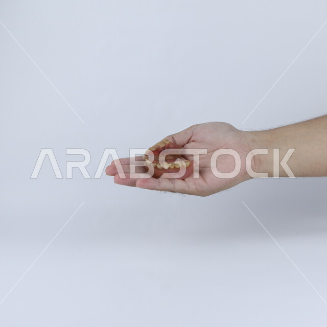 يد تحمل طقم أسنان متسخ ، تلبيس الأسنان ، خلفية بيضاء