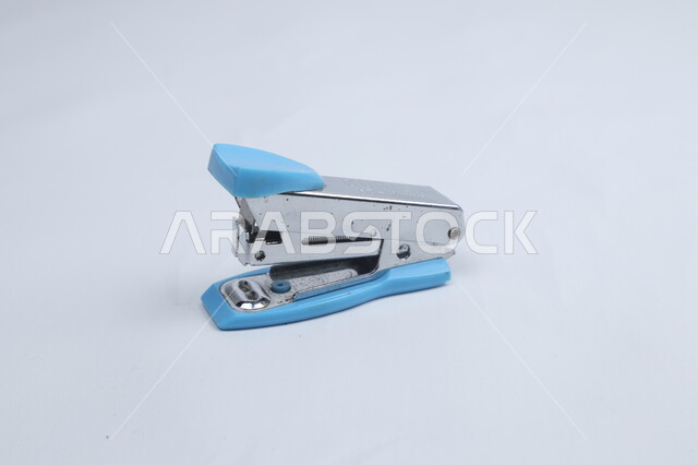 دباسة ورق زرقاء، أدوات مكتبية، كابسة الورق، قرطاسية، خلفية بيضاء