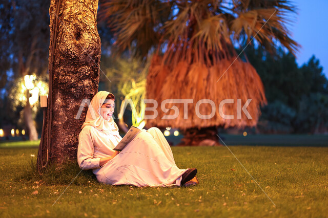 امرأة عربية خليجية سعودية تقضي أوقات ممتعة في إحدى الحدائق العامة، قراءة القصص والروايات، الإستمتاع بقراءة الكتب، التثيف واكتساب المعرفة، الجلوس في الهواء الطلق