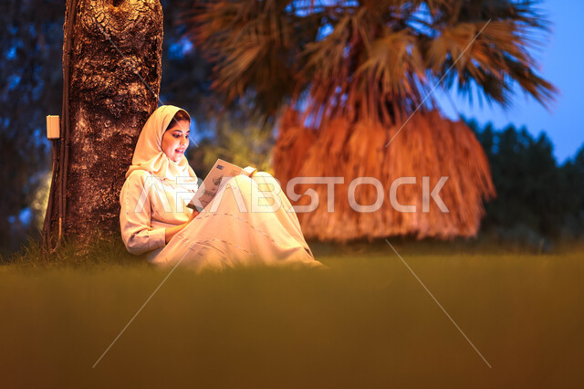 امرأة عربية خليجية سعودية تقضي أوقات ممتعة في إحدى الحدائق العامة، قراءة القصص والروايات، الإستمتاع بقراءة الكتب، التثيف واكتساب المعرفة، الجلوس في الهواء الطلق