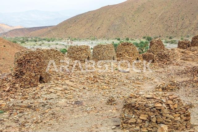 Vertical view of ancient beehive‑shaped stone tombs on a rocky ridge at ...