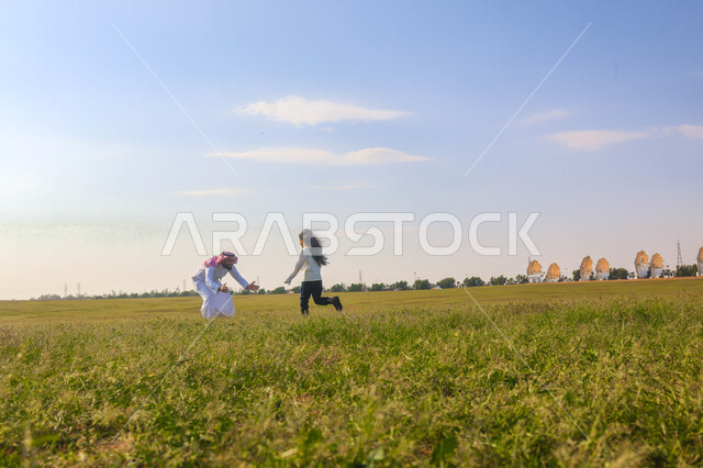 أب عربي سعودي خليجي يقضي اوقات ممتعة مع ابنته في إحدى الحدائق, عطلة صيفية، نزهه في الهواء الطلق، جولة في الطبيعة الخضراء، مزرعة واستراحات، أنشطة ترفيهية عائلية