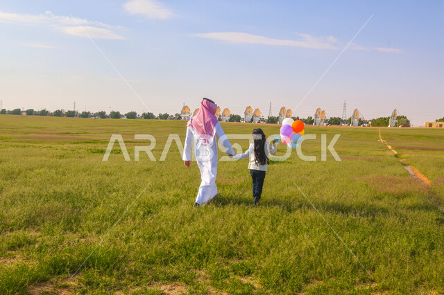 أب عربي سعودي خليجي يقضي اوقات ممتعة مع ابنته في إحدى الحدائق، بالونات ملونه, عطلة صيفية، نزهه في الهواء الطلق، جولة في الطبيعة الخضراء، مزرعة واستراحات، أنشطة ترفيهية عائلية