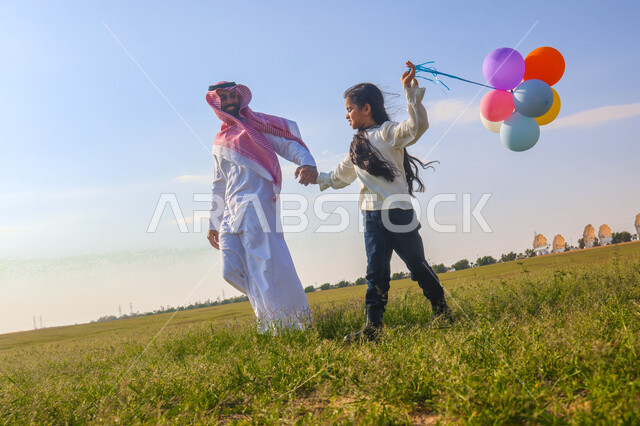 أب عربي سعودي خليجي يقضي اوقات ممتعة مع ابنته في إحدى الحدائق، بالونات ملونه, عطلة صيفية، نزهه في الهواء الطلق، جولة في الطبيعة الخضراء، مزرعة واستراحات، أنشطة ترفيهية عائلية