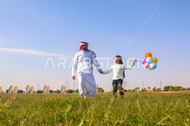 An Arab, Saudi, Gulf father spending fun times with his daughter in a park, colorful balloons, summer vacation, outdoor picnic, green nature tour, farm and restrooms, family entertainment activities