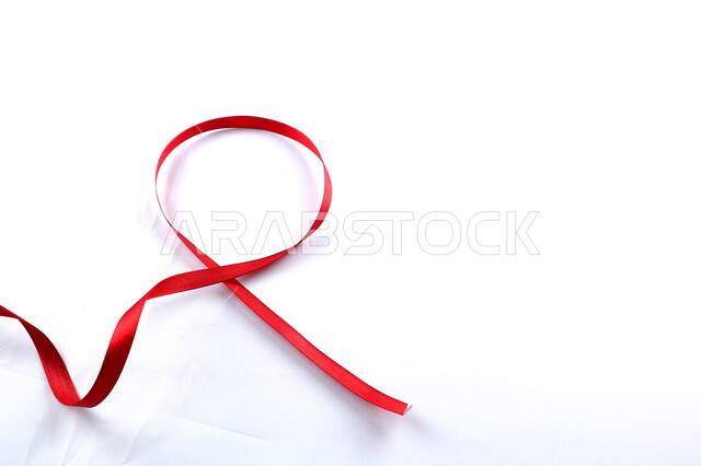 Red ribbon on a white background, HIV awareness, World AIDS Awareness Day, white background.