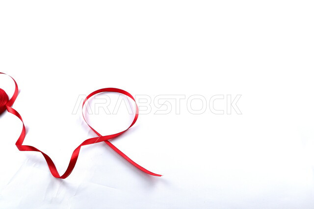 Red ribbon on a white background, HIV awareness, World AIDS Awareness Day, white background.