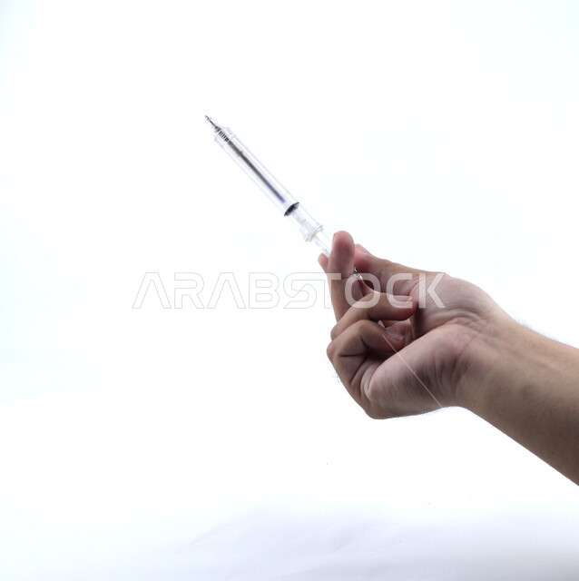 صورة مقربة ليد تمسك إبره طبيه، تطعيم، تجهيز الحقنة، معدات وأدوات طبية, لقاح طبي ، خلفيه بيضاء