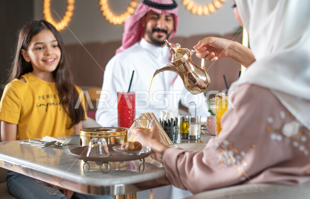 كافيهات ومطاعم في السعودية, عائلة عربية سعودية خليجية تجلس في المقهى,  إيماءات تدل على السعادة, قضاء وقت ممتع في الخارج و تناول المشروبات مع العائلة, دردشة ومحادثات .