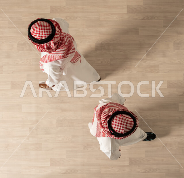  المشي في مقر الشركه، صوره علويه عاموديه لرجلان عربيان سعوديان خليجي يرتديان الزي السعودي التقليدي ،قدوم وخروج الموظفين، مهن ووظائف، شركات عربيه سعوديه خليجيه