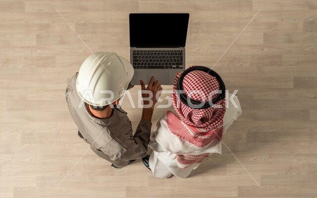 فرص عمل، صورة علوية عامودية لرجلان عربيان خليجيان سعوديان في وظائف مختلفة بالسعودية ، مهنة الهندسة المعماريه والمدنيه ، مهن ووظائف سعودية، العمالة السعودية، عمل جماعي مشترك