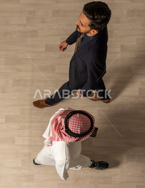 شركات عربيه سعوديه خليجيه ، صوره علويه عاموديه لرجل عربي سعودي خليجي يرتدي الزي السعودي التقليدي  ورجل عربي يرتدي البدله الرسميه، المشي في مقر الشركه، قدوم وخروج الموظفين، مهن ووظائف
