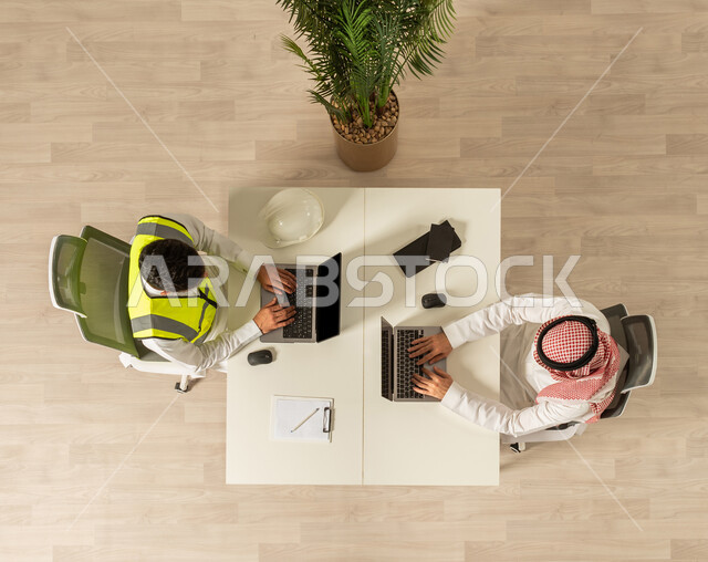 انجاز مهام العمل، صوره علويه عاموديه لزملاء عمل في مقر الشركه، استخدام جهاز الحاسوب المحمول،  اعمال مكتبيه، هندسه معماريه ، مهن ووظائف سعوديه