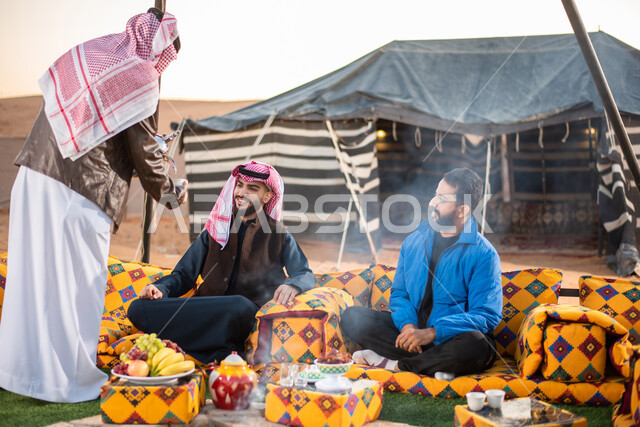 دلة قهوة عربية، مجموعة من الاصدقاء العرب الخليجيين السعوديين يستمتعون برحلة برية في الصحراء، تقديم القهوة الساخنة للضيوف، حسن الضيافة والإستقبال، جلسة عربية شعبية، خيام في صحاري السعودية، كشتة بر شبابية