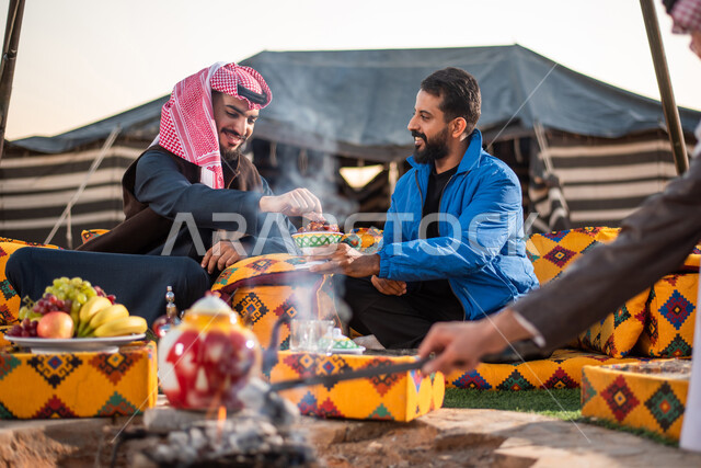 حسن الاستقبال وكرم الضيافة في المملكة العربية السعودية، صورة مقربة لصديقان عربيان خليجيان سعوديان يستمتعان برحلة تخييم برية في الصحراء، طبق من حبات التمر الخليجي الشهي، قضاء أوقات ممتعة مع الأصدقاء، مخيمات سياحية في صحاري السعودية، كشتة بر عربية شيابية