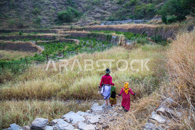 صورة من الخلف لأطفال يقفون وسط الطبيعة في جبال الفيفاء في جازان بالمملكة العربية السعودية، الطبيعة الجبليه الخضراء في جازان، مزارع البن, خلفية الطبيعه