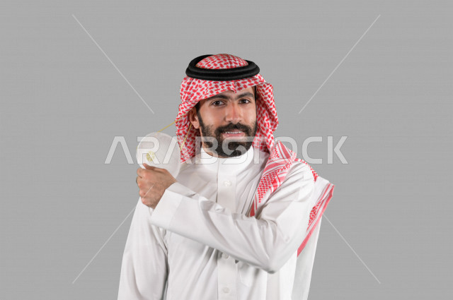 بورتريه لشاب عربي خليجي سعودي يقوم بإزالة الكمامة الواقية، اتخاذ اجراءات الوقاية من فايروس كورونا (كوفيد-19)، خلفية بيضاء