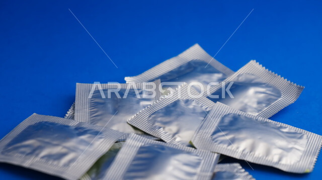 Close-up of a group of medicines wrapped in aluminum foil, blue background, treatment of diseases, pharmacy, medicines and drugs