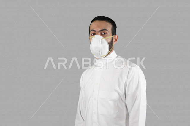 بورتريه لشاب عربي خليجي سعودي، ارتداء الكمامة الواقية، اتخاذ اجراءات الوقاية من فايروس كورونا (كوفيد-19)، ايماءات وجه ويدين مختلفة، خلفية بيضاء