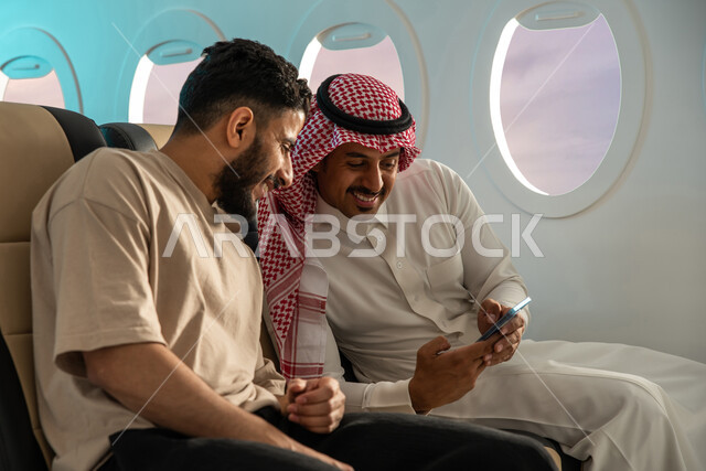 الخطوط الجوية السعودية ، دردشة ومحادثات ، مسافران عربيان خليجيان سعوديان في مقعد الطائر ، ايماءات تدل على الفرحة والسرور ، قضاء أوقات ممتعة برفقة الاصدقاء ،  اجازة صيفية سعيدة ، سياحة وسفر ، رحلات جوية سياحية .