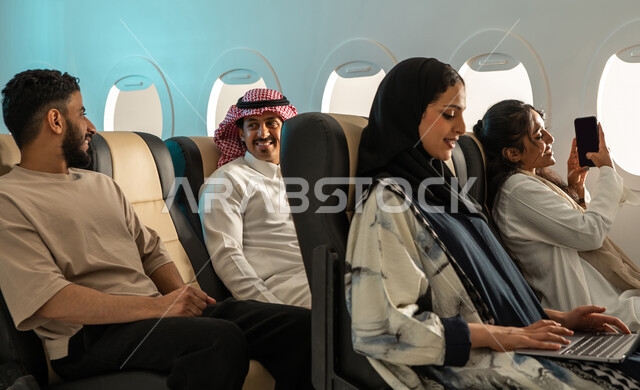  رحلة سياحية شبابية ، مجموعة من الركاب العرب الخليجيون السعوديون في مقصورة  الطائرة ، عطلة صيفية سعيدة ، الخطوط الجوية السعودية ، ايماءات تدل على السعادة ،  قضاء أوقات ممتعة برفقة الاصدقاء ، دردشة ومحادثات.