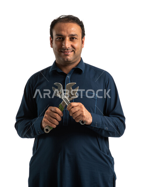 بورتريه لعامل بناء باكستاني يرتدي الزي الباكستاني التقليدي ويمسك بمفتاح سباكة فرنساوي، ادوات السباكة، مفتاح صلب، مهندس معماري، ادوات التشطيب، استقدام العمالة من الخارج، خلفية بيضاء
