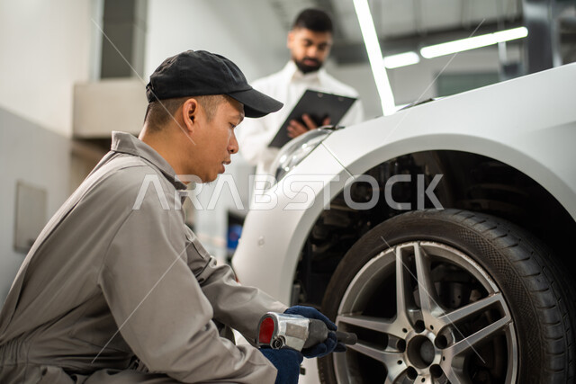 عامل صيانه ميكانيكي يقوم بنفخ واصلاح عجلات السياره , استخدام أدوات الصيانه المناسبه, اصلاح يدوي متميز, تدوين وكتابة الملاحظات ,إصلاح سيارة عميل عربي سعودي خليجي في الورشه, التشييك وتصليح السيارات في مركز الصيانه, مهندس ميكانيكي محترف