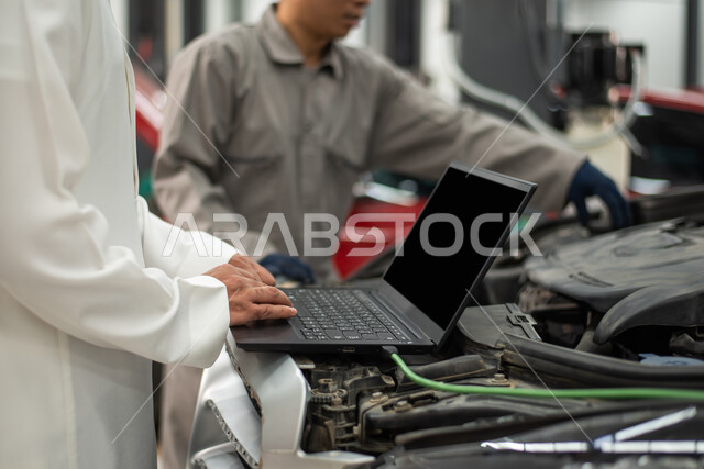 Car repair request via laptop, close-up of a maintenance worker repairing a Saudi Arabian Gulf customer's car in the workshop, gestures indicating satisfaction and acceptance of the workshop's services, checking and repairing cars in the maintenance cente