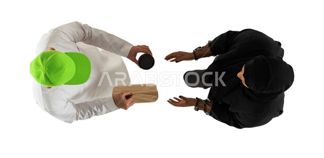 مندوب توصيل يرتدي قبعة خضراء ويقوم بتسليم الطلبات للزبائن، امرأة تستلم مشترياتها، خدمات التوصيل السريع للمشروبات الساخنة، صورة علوية عامودية لرجل وامرأة عربيان خليجيان سعوديان، عملية شراء وتوصيل موثوقة وناجحة، خلفية بيضاء