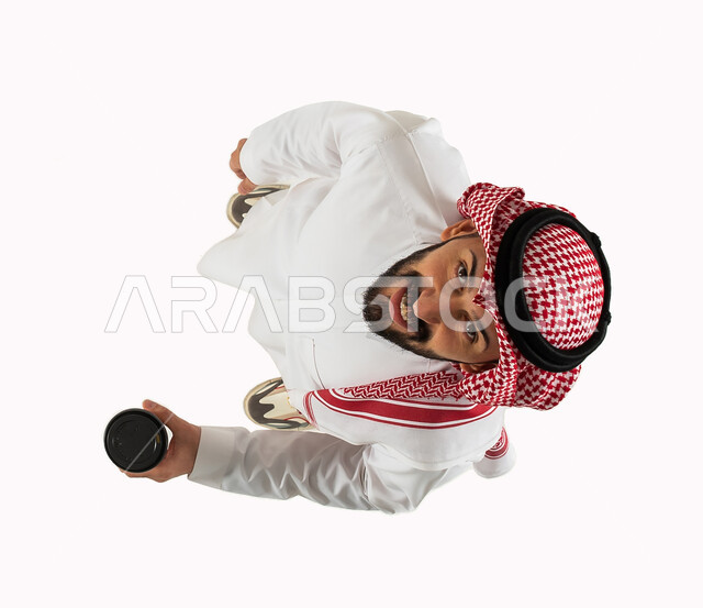 Receipt of purchases and orders, vertical overhead image of a Saudi Arabian Gulf man holding a cup of coffee, smart electronic shopping and online orders, facial gestures indicating happiness, reliable purchase and delivery process, express delivery servi