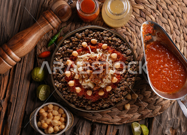 طبق من الكشري المصري الشهير، أطباق شعبية تقليدية، مائدة طعام، مطاعم عربية شرقية، وصفات وأطباق طعام لذيذة، طبق من الارز والمعكرونة المزينة بالصلصة الحارة 