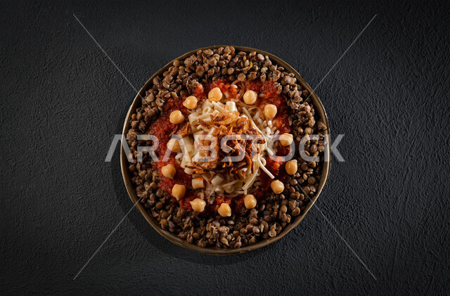 طبق من الكشري المصري الشهير، أطباق شعبية تقليدية، مائدة طعام، مطاعم عربية شرقية، وصفات وأطباق طعام لذيذة، طبق من الارز والمعكرونة المزينة بالصلصة الحارة 