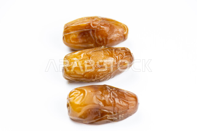 صورة مقربة لحبات التمر الصحي، تمر دقلة نور، ضيافة رمضانية، التمور اللذيذة، خلفية بيضاء