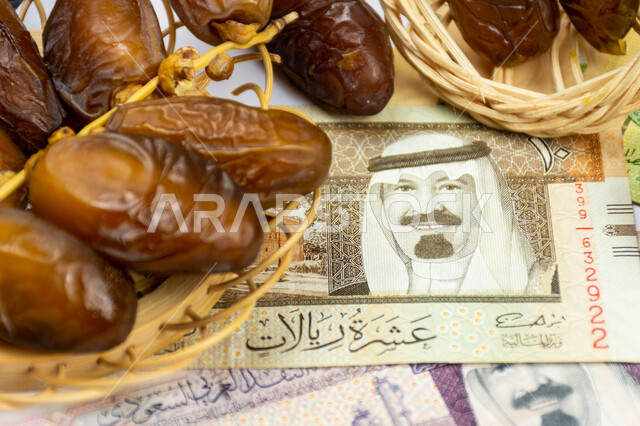 صورة مقربة لحبات التمر مع ورقة نقدية  10  ريال سعودي ، تمر دقلة نور، ضيافة رمضانية، التمور السعودية ، اوراق نقدية، الريال السعودي، شراء منتج التمر ، تجارة التمور السعودية ، رمضان