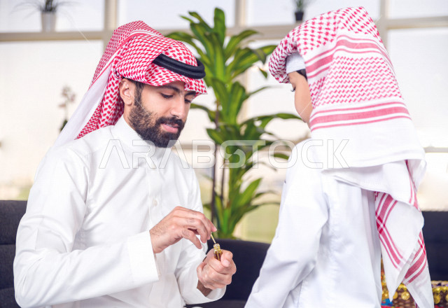 مشاركة رائعة لأب عربي خليجي سعودي مع ابنه في صباح يوم العيد ، تقديم العيدية بسعادة ، ارتداء اللباس السعودي التقليدي ، العيدية ، القرقيعان ، احتفالات و مظاهر العيد ، عطلة رسمية ، قضاء أوقات عائلية سعيدة في العيد