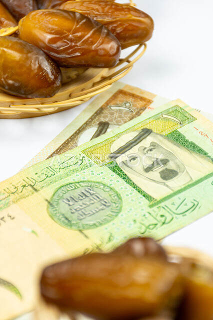 صورة مقربة لحبات التمر مع ورقة نقدية  10  ريال سعودي ، تمر دقلة نور، ضيافة رمضانية، التمور السعودية ، اوراق نقدية، الريال السعودي، شراء منتج التمر ، تجارة التمور السعودية ، رمضان
