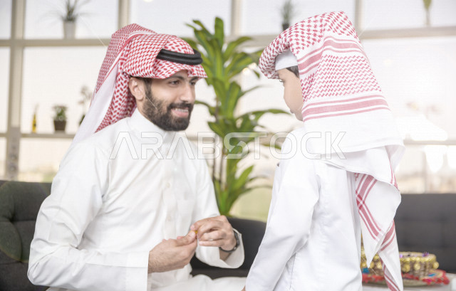 مشاركة رائعة لأب عربي خليجي سعودي مع ابنه في صباح يوم العيد ، تقديم العيدية بسعادة ، ارتداء اللباس السعودي التقليدي ، العيدية ، القرقيعان ، احتفالات و مظاهر العيد ، عطلة رسمية ، قضاء أوقات عائلية سعيدة في العيد