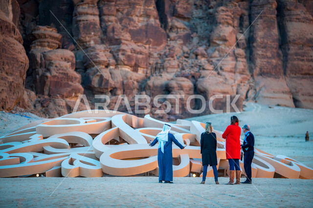 مرشد سياحي عربي خليجي سعودي مع مجموعة من السياح في العلا بالمملكة العربية السعودية، الطبيعة الصحراوية، معالم تاريخية أثرية قديمة، التكوينات الصخرية، أماكن سياحية