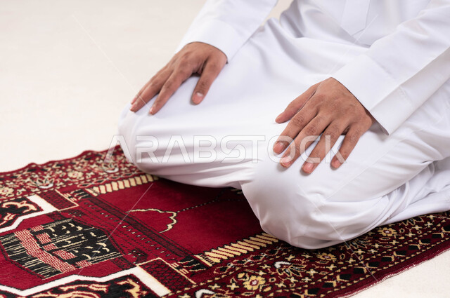 A close-up of a Saudi Arabian Gulf man, performing the obligatory prayer, Islamism and worship, the concept of the pillars of Islam, a white background