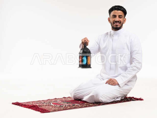 بورتريه لرجل عربي خليجي سعودي ، يحمل فانوس رمضان ، الإستعداد لقدوم شهر رمضان المبارك ، المناسبات الدينية والأعياد الإسلامية ، رمضان كريم ، إسلاميات وعبادة ، خلفية بيضاء