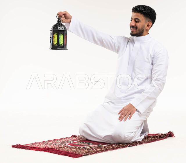 Portrait of a Saudi Arabian Gulf man, carrying a Ramadan lantern, preparing for the advent of the blessed month of Ramadan, religious occasions and Islamic holidays, Ramadan Kareem, Islamic and worship, white background
