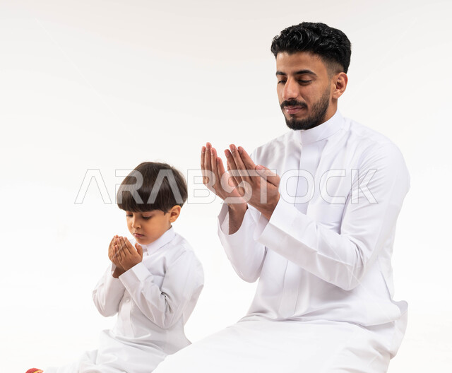 بورتريه لرجل عربي خليجي سعودي مع إبنه ، يرفعان إيديهما لأعلى ، أدعية وأذكار ، إسلاميات وعبادة ، خلفية بيضاء ، تعليم العبادة والصلاة للأطفال