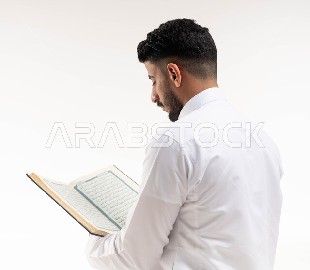 بورتريه لرجل عربي خليجي سعودي ، يحمل بيده المصحف الشريف ، قراءة القرآن الكريم ، إسلاميات وعبادة ، تلاوة وحفظ القرآن الكريم ، خلفية بيضاء