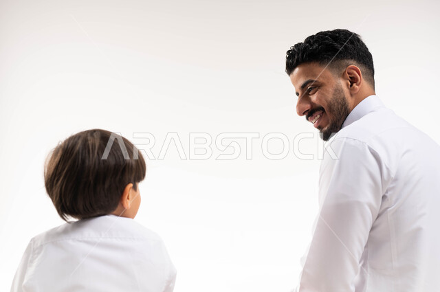 بورتريه لرجل عربي خليجي سعودي مع إبنه ، حوارات ونقاشات ، إسلاميات وعبادة ، خلفية بيضاء ، تعليم العبادة والصلاة للأطفال