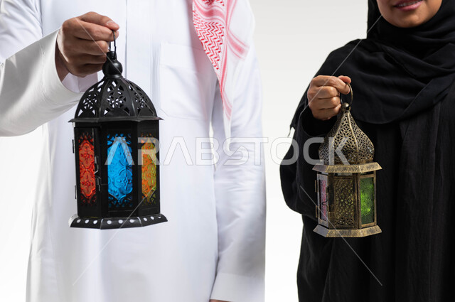 صورة مقربة لزوجان عربيان خليجيان سعوديان ، فانوس رمضان ، الإستعداد لقدوم شهر رمضان المبارك ، المناسبات الدينية والأعياد الإسلامية ، رمضان كريم ، إسلاميات وعبادة ، خلفية بيضاء