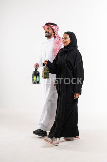 بورتريه لزوجان عربيان خليجيان سعوديان ، فانوس رمضان ، الإستعداد لقدوم شهر رمضان المبارك ، المناسبات الدينية والأعياد الإسلامية ، رمضان كريم ، إسلاميات وعبادة ، خلفية بيضاء ، صورة بالطول الكامل