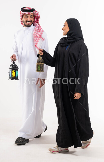 بورتريه لزوجان عربيان خليجيان سعوديان ، فانوس رمضان ، الإستعداد لقدوم شهر رمضان المبارك ، المناسبات الدينية والأعياد الإسلامية ، رمضان كريم ، إسلاميات وعبادة ، خلفية بيضاء ، صورة بالطول الكامل